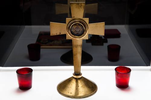 This tetropod, or Table of Needs, holds a cross with a Holy Relic of St. Josephat, candles, icons and a cloth. Other items are placed on the tetropod as needed.